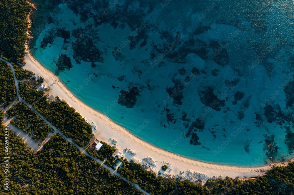 View from above, stunning aerial view of a white sand beach bathed by a turquoise water. Long Beach, Liscia Ruja, Sardinia, Italy.