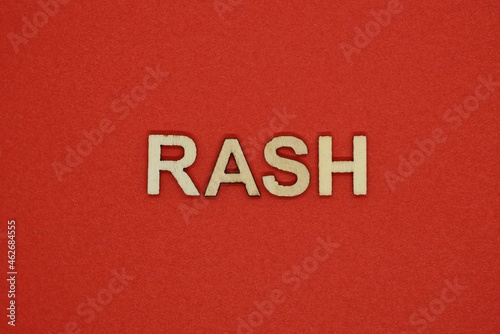text the word rash from gray wooden small letters on an red table