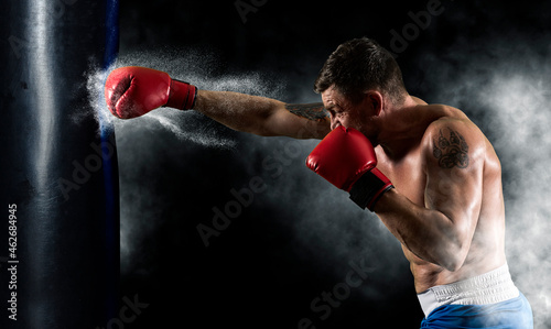 Boxer at the moment of impact on punching bag © Andrey Burmakin