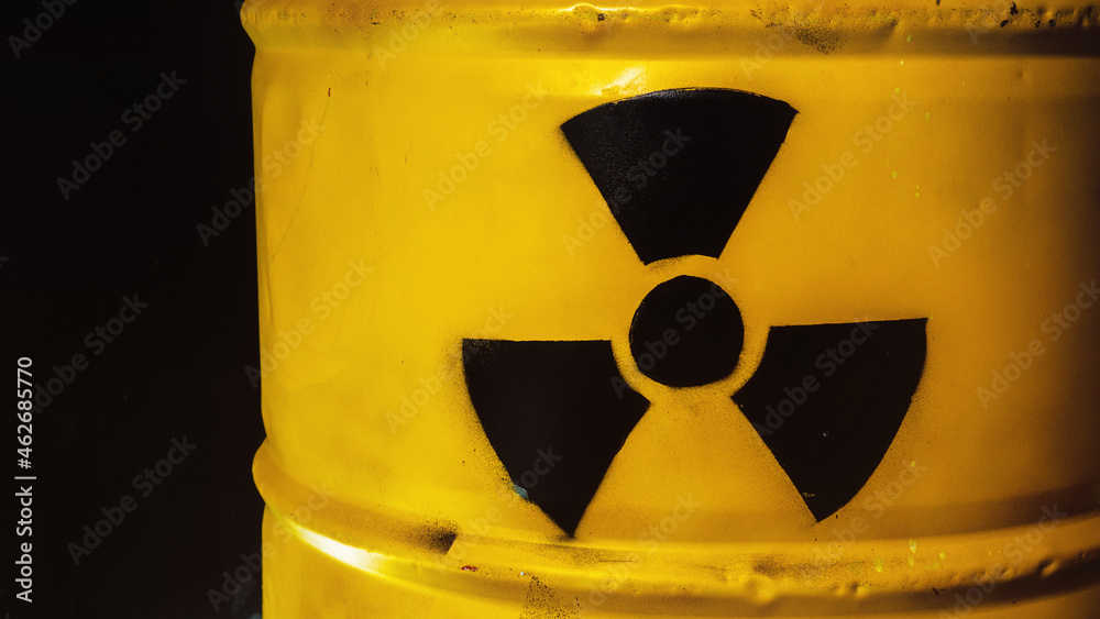 Fototapeta premium Yellow metal barrel with radioactive decay symbol. Container with nuclear trefoil warning sign. Drum with toxic hazardous waste. Disposal, utilization problem. Environmental harm