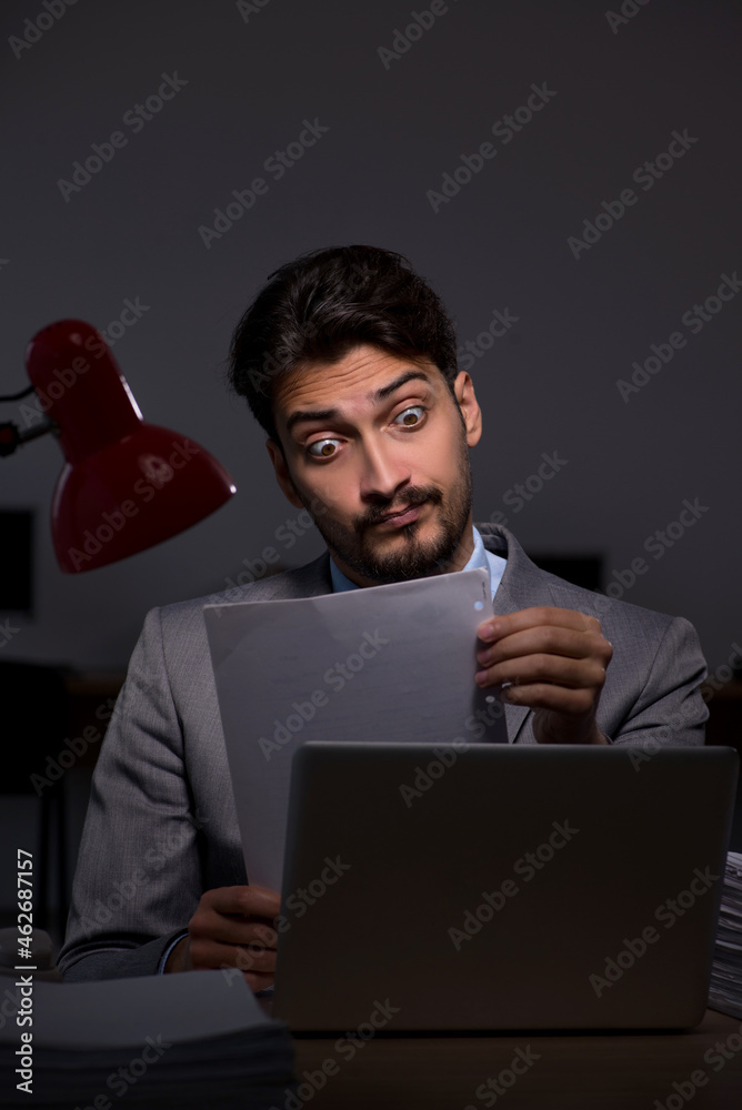 Young male employee working late in the office Young male employee working late in the office