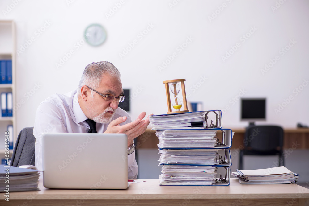 Old male employee in time management concept Old male employee in time management concept