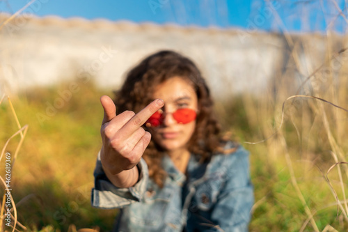 Young woman giving the finger, close-up photo