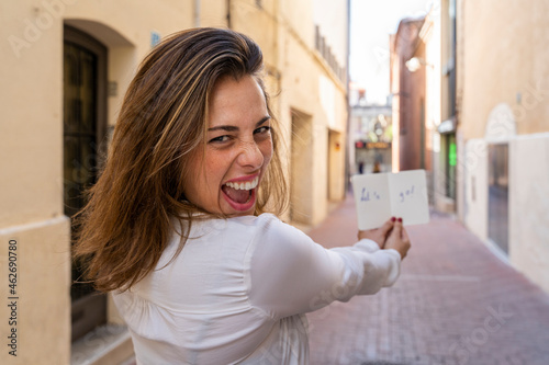 Young woman with notebook 'Let's go!' in an alley