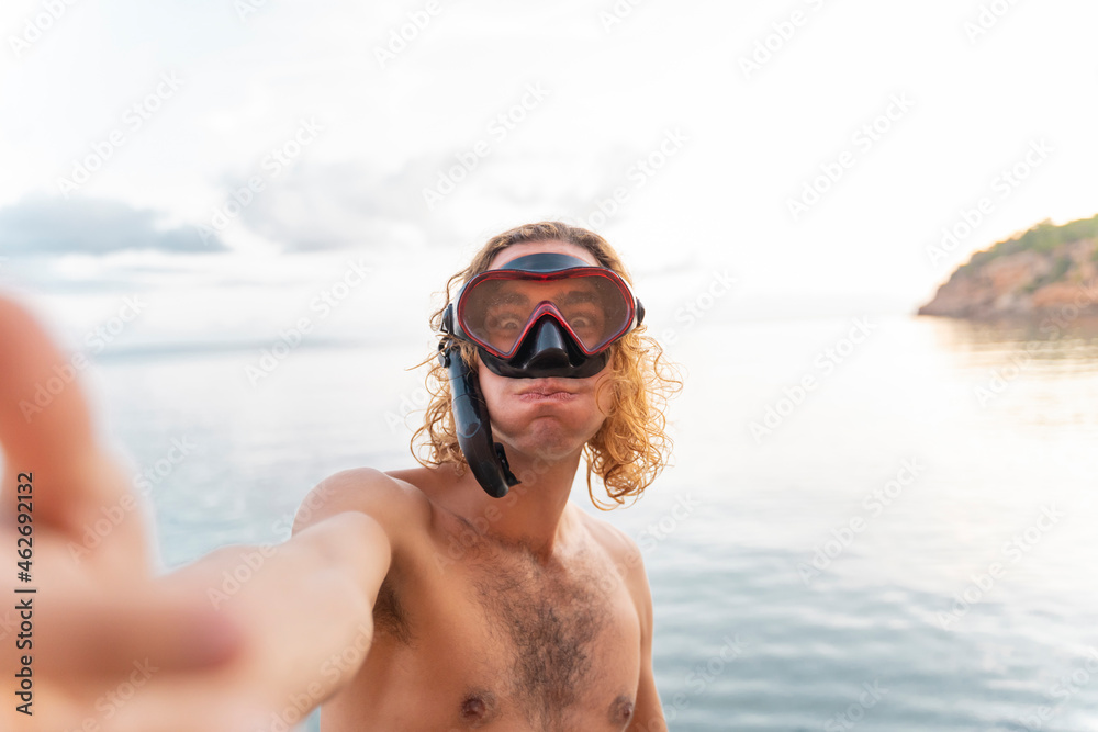 Young man with snorkel making a face on the beach Young man with snorkel making a face on the beach