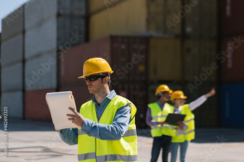 Workers in front of cargo containers on industrial site photo