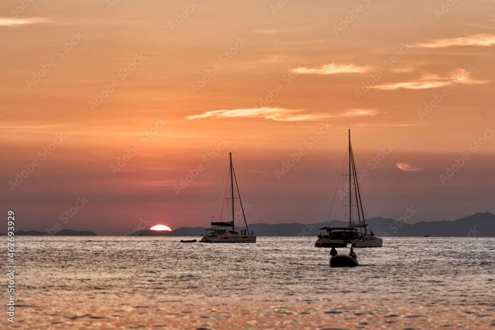 Thailand, Krabi, Railay beach, boats floating on water at sunset Thailand, Krabi, Railay beach, boats floating on water at sunset