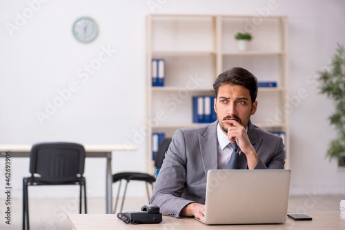 Young male employee and too much work in the office