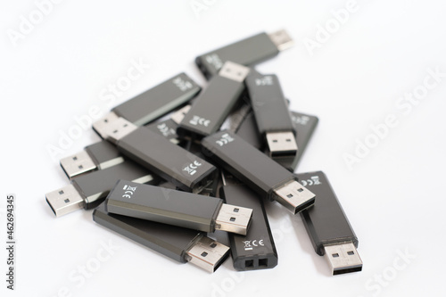 Pile of black USB flash drive sticks with white background photo