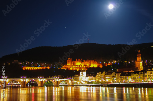 Night view with illumination of old bridge, downtown and castle in Heidelberg, Germany