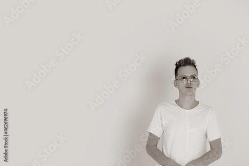 Attractive brutal guy posing and blank white t-shirt made of thin summer cotton, over white background with copy space