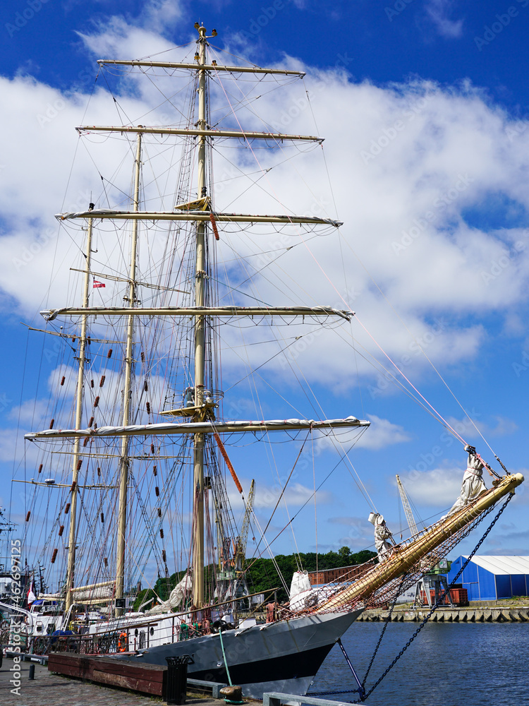a historic sailing ship with three masts at the port berth