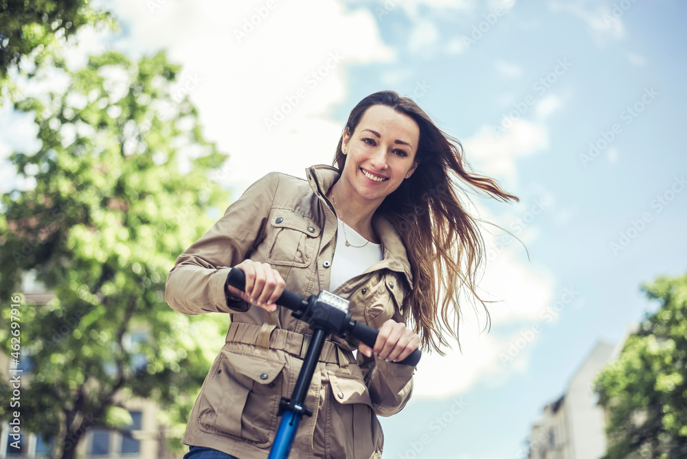 Portrait of smiling woman with E-Scooter Portrait of smiling woman with E-Scooter