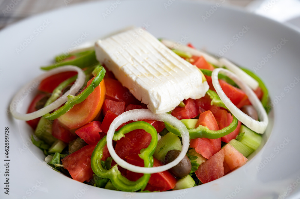 Summer healthy food, vegetable greek salad made with fresh cucumber, tomatoes, onion, feta cheese, green paprika and olives Summer healthy food, vegetable greek salad made with fresh cucumber, tomatoes, onion, feta cheese, green paprika and olives