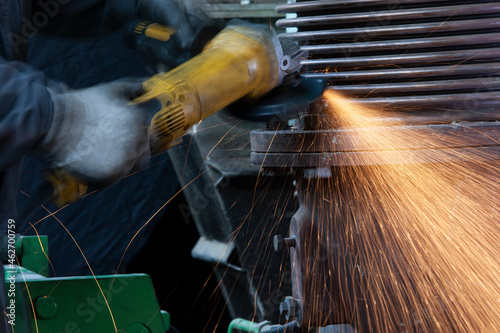 Close-up of worker using angle grinder in a factory