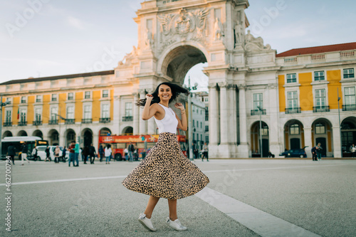 Happy young woman dancing in the city, Lisbon, Portugal photo