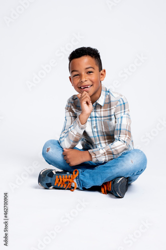 Portrait of happy boy sitting against white background