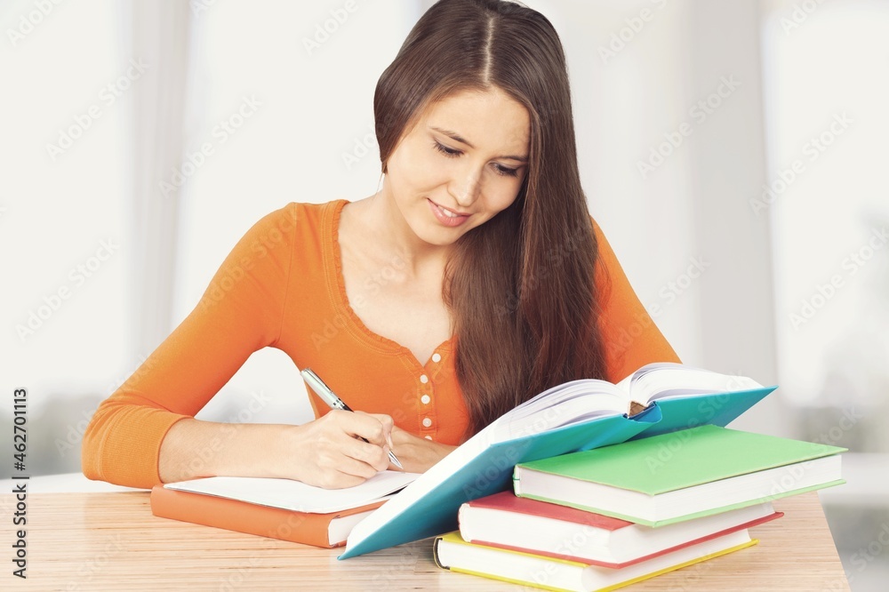 Human sitting at desk and writing down notes on a notebook Human sitting at desk and writing down notes on a notebook