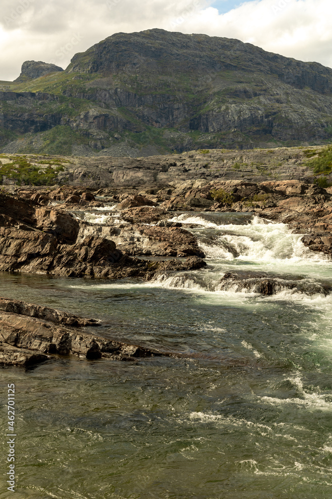 The waterfall in the national park Stora Sjöfallet in Sweden. This is made near the Storasjofallet Mountain lodge. Made in the summer time. The waterfall in the national park Stora Sjöfallet in Sweden. This is made near the Storasjofallet Mountain lodge. Made in the summer time.