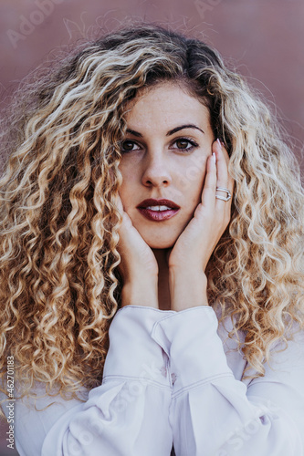 Portrait of young woman with dyed blond ringlets