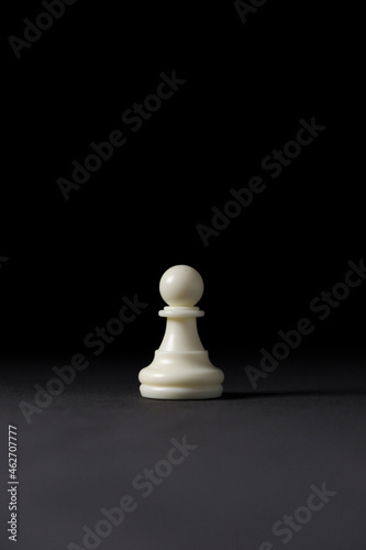 isolated white pawn chess piece on black background