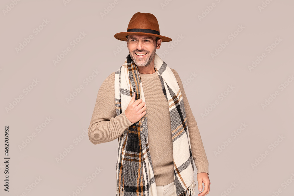 Cheerful handsome guy in fashionable autumn clothes, hat and scarf, posing in studio. Cheerful handsome guy in fashionable autumn clothes, hat and scarf, posing in studio.