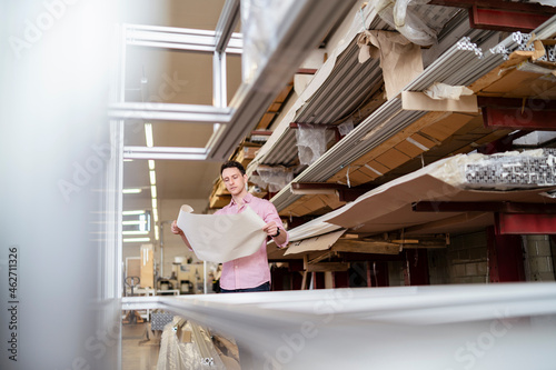 Man with plan in factory warehouse