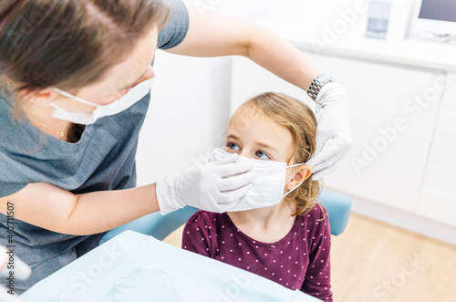 Girl at the dentist receiving mask