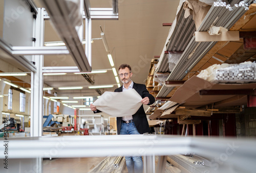 Businessman with plan in factory warehouse photo