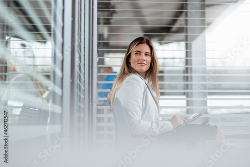 Young businesswoman using tablet in a waiting area