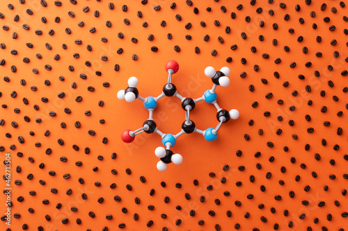 Directly above view of caffeine chemical formula with roasted coffee beans over orange background photo