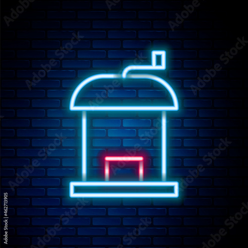 Glowing neon line Manual coffee grinder icon isolated on brick wall background. Colorful outline concept. Vector
