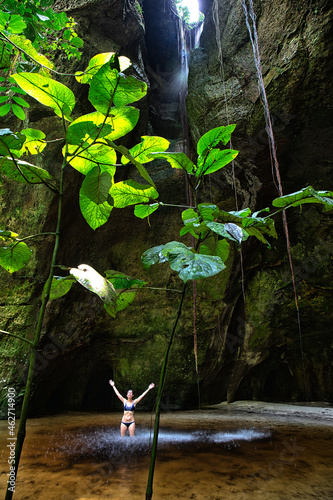 Woman bathing in the waterfall in the Judeia cave in Amazon region, Brazil photo
