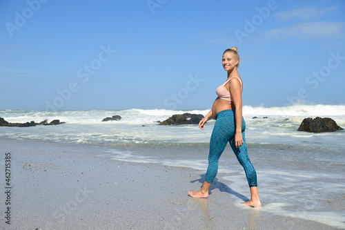 Portrait of happy pregnant woman on the beach wading in the sea photo