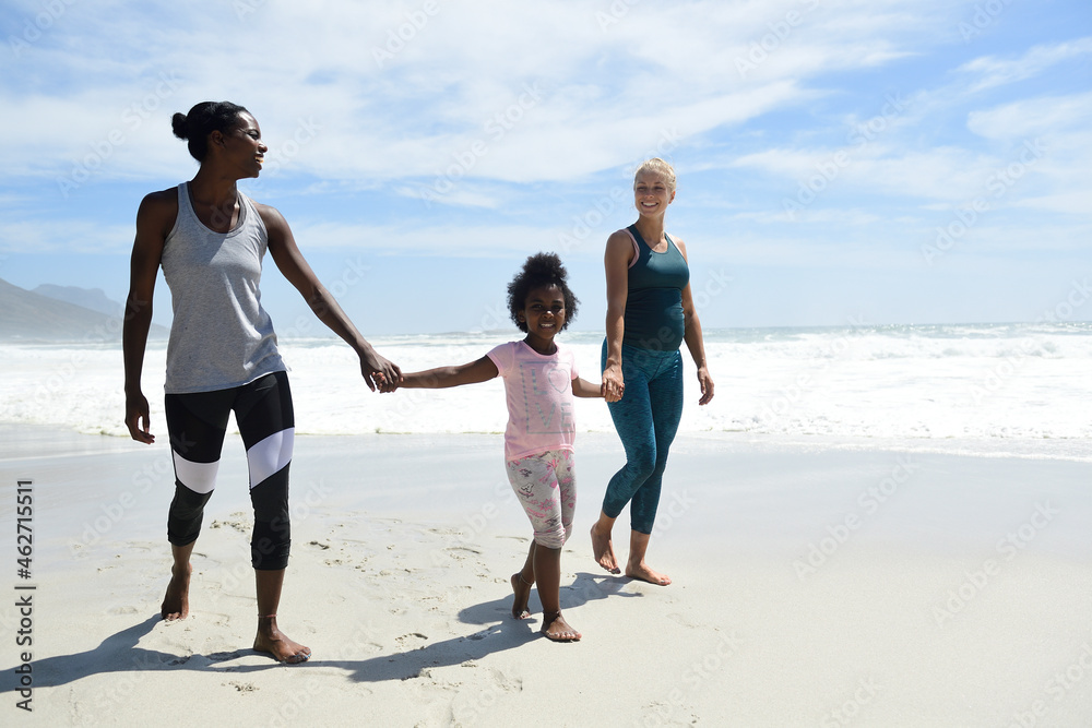 Happy mother with daughter and friend walking on the beach Happy mother with daughter and friend walking on the beach