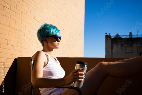 Androgyne young woman with blue hair on the balcony photo