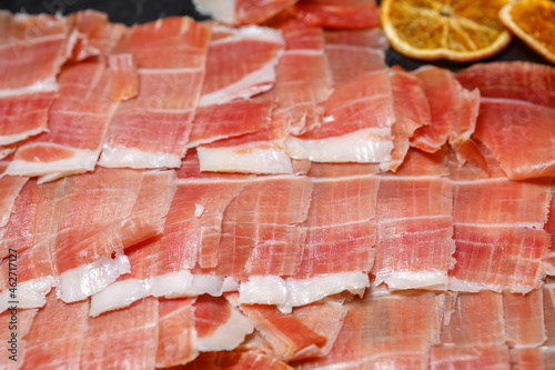 Sliced ham in thin slices lies on a tray. photo