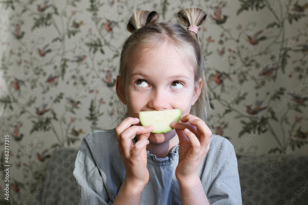 Portrait of blond girl with slice of courgette Portrait of blond girl with slice of courgette