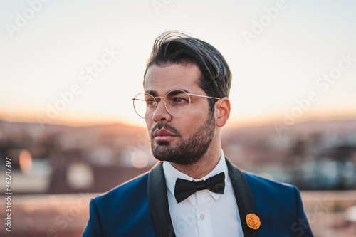 Portrait of stylish man on roof terrace at sunset photo