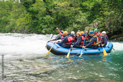 Group of people rafting in rubber dinghy on a river photo
