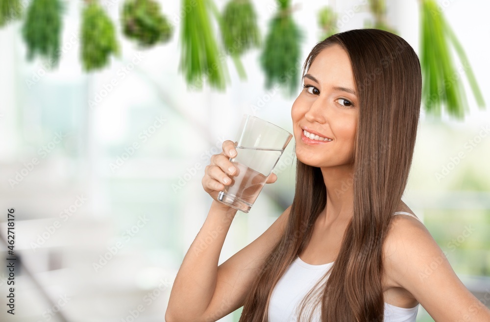 Smiling pretty woman holds a glass of water on kitchen Smiling pretty woman holds a glass of water on kitchen
