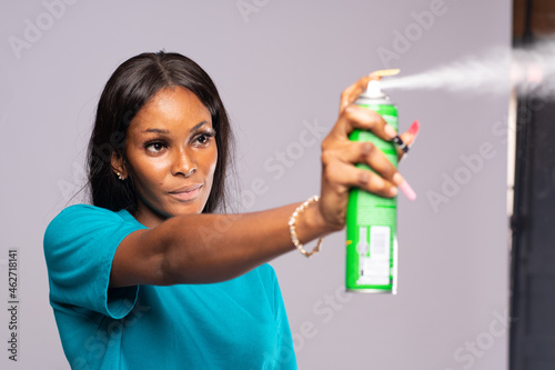 young lady spraying an insecticide photo