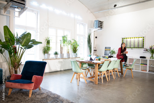 Woman sitting on table in modern office photo