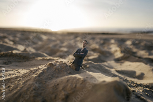 Businessman figurine stuck in sand photo