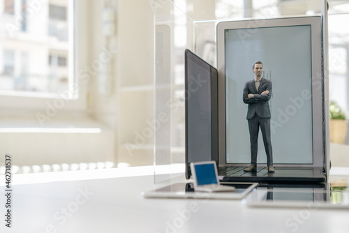 Wallpaper Mural Businessman figurine standing on portable devices in a glass cage Torontodigital.ca