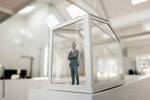 Businessman figurine standing in glasshouse