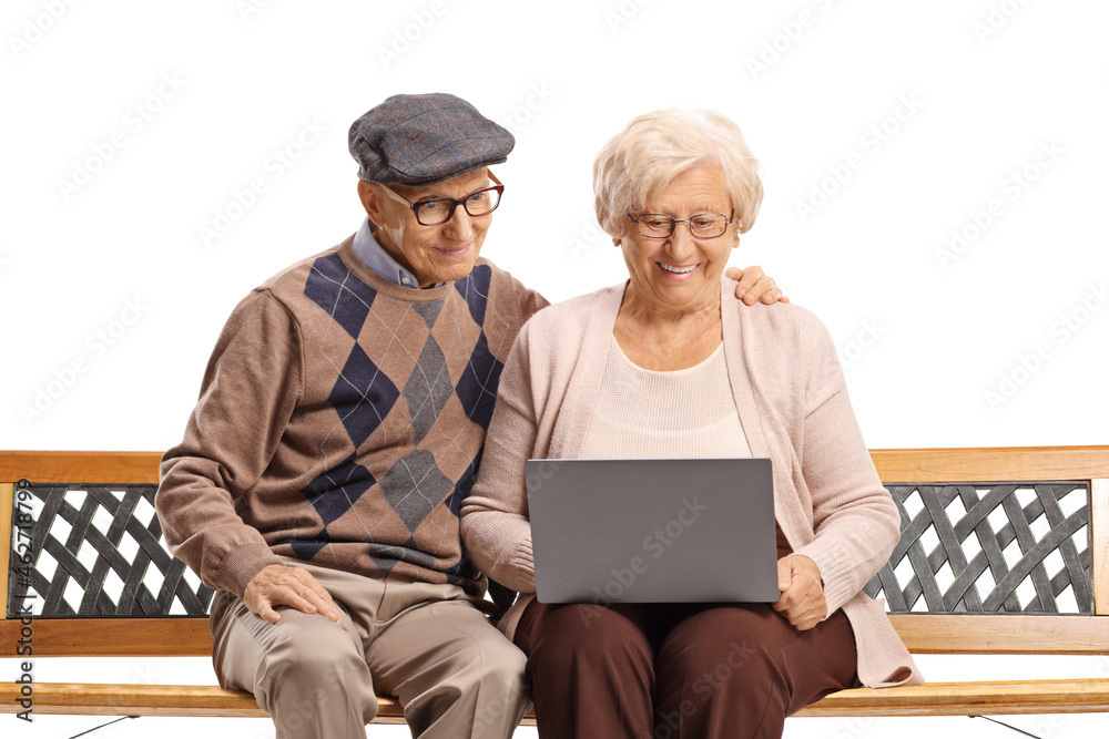 Elderly couple on a bench with a laptop computer Elderly couple on a bench with a laptop computer