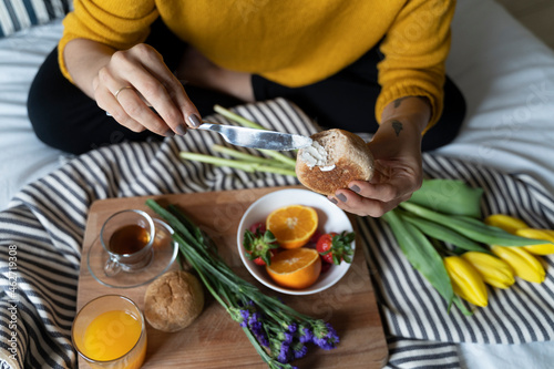 Woman sitting on bed, having a healthy breakfast photo