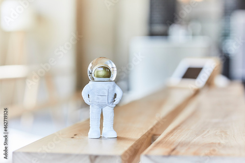 Miniature astronaut figurine on wooden bench