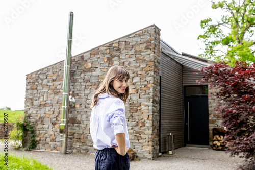 Smiling woman standing in front of a house photo